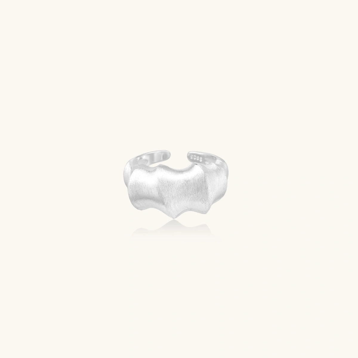 Brushed sterling silver ring with organic wave-like edges and adjustable cuff design on white background