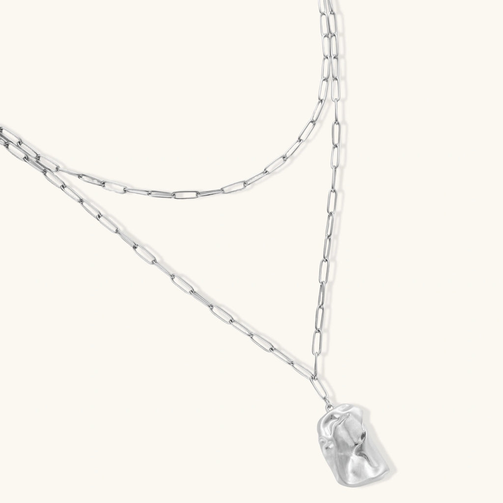 Modern textured hoop earrings and layered chain necklace with liquid metal pendant in silver and gold finishes.